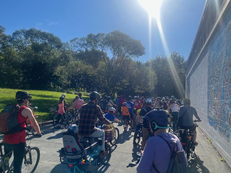 
A large group is gathered before the Dartmouth ride. Bubbles are coming from the back of one bike.

